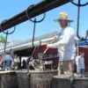 Troy Miller stirs the bean soup in one of the massive cast iron kettles hanging over a fire pit at the Friendship Fire Co. block party in Englewood.