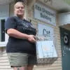 Sherrie Schafer, shelter manager at Hillside SPCA, holds a feral cat trap that could be used as part of a TNR program.